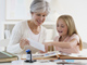 Grandmother and granddaughter working on scrap book at home