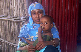 Mekeya, here sitting with her child, is a community champion in the Afar region, Ethiopia.