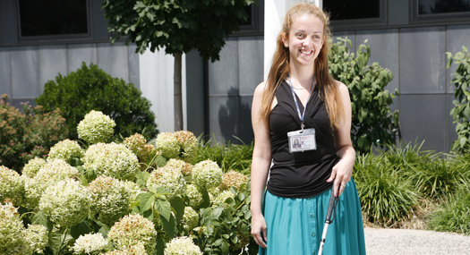 smiling woman holding white cane