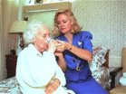 Photo of woman helping an Alzheimer's patient drink. - Click to enlarge in new window.