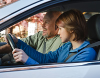 Una adolescente al volante de un automóvil con su padre