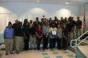 Romanita Ford (speckled shirt right center) and Joseph Prater (dress shirt, center) of Community Health of South Florida thanked the Homestead Job Corps Center Security trade students and their instructor (yellow shirt holding certificate) Reginald Davis.  Lesly Diaz, the Center's  Business & Community Liaison, is next to him in brown jacket. Click for a larger image.