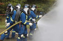 A mine rescue team battles a fire on the Mine Academy's burn pad. Click for more photos.