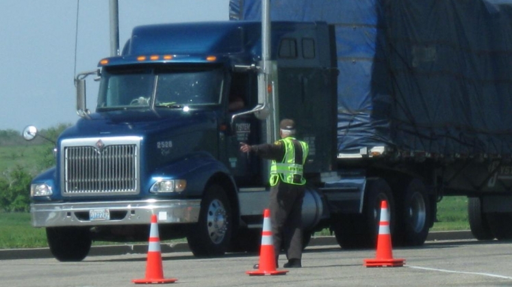 A truck being directed by a safety officer. 