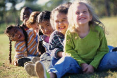Photograph of smiling children sitting outside