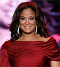 A close up image of Laila Ali in a red dress walking down the fashion runway.