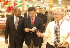 Image of Mayor Nutter, Secretary Locke and reporter with microphone in store. Click for larger image.