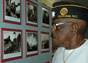 A Korean War Veteran looks at a wall of Korean War photos