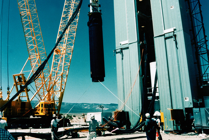 The "Divider" test rack is hoisted into position for lowering down hole at the Nevada Test Site in September of 1992.  Divider was the last full scale underground nuclear test conduced by the United States.
