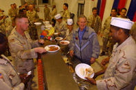 President George W. Bush meets with troops and serves Thanksgiving dinner at the Bob Hope Dining Facility, Baghdad International Airport, Iraq, on November 27, 2003. (P36047-34)