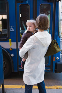 woman holding a baby while waiting for the bus