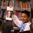 A student holds up a book about President George W. Bush, October 3, 2006, during the President's visit to the elementary school named after him in Stockton, California. (P100306ED-0245)