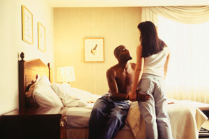 man and woman in a bedroom talking