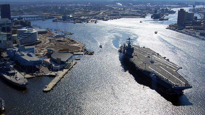 A Nimitz-class aircraft carrier transits up the Elizabeth River