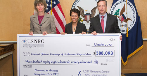 NRC Chairman Allison Macfarlane (left to right), Dr. Dipti Singh, representative of the Combined Federal Campaign of the National Capital Area, and Bill Borchardt, executive director of the NRC Office of Operations, pose with giant check representing the $588K that the agency employees donated to different charities in 2011 surpassing their original $525K goal.