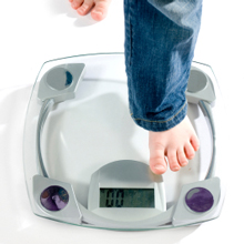 Photo of a child's foot stepping onto a scale.