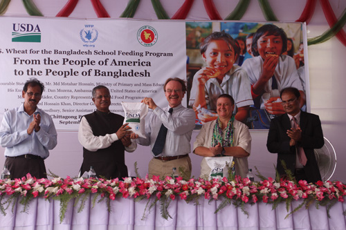 United States Ambassador to Bangladesh Dan W. Mozena (center) hands over a ceremonial bag of wheat to Bangladesh’s State Minister for Primary and Mass Education Md Motahar Hossain during a ceremony at a Bangladeshi port last month. The event marked the donation of more than 10,000 metric tons of wheat to the country through the Foreign Agricultural Service’s (FAS) McGovern-Dole Food for Education Program. The wheat will be used to provide approximately 350,000 Bangladeshi school children with a nutritious snack. (Photo courtesy U.S. Embassy New Dehli) 