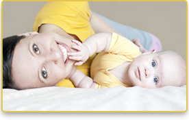 Una mujer y su bebé sonríen, ambos  vistiendo camisetas amarillas,