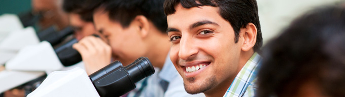 Male students using microscopes