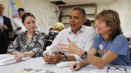 U.S. President Barack Obama (C) jokes about a telephone with campaign volunteers Alexa Kissinger (L) and Suzanne Stern as he makes calls from a campaign office in Williamsburg, Virginia, October 14, 2012. REUTERS/Jonathan Ernst