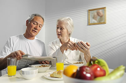 una pareja leyendo un periódico al desayuno