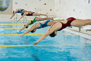 Photo of swimmers diving into the water for a race