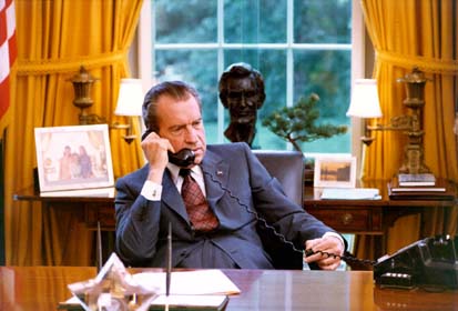 Candid photo of President Nixon at his desk in the Oval Office