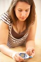 teen checking her blood sugar levels