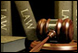 Image of law books behind a gavel that is used in the courtroom.