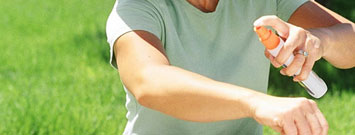 Una persona aplicándose repelente en su brazo