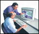 Two employees viewing computer screen
