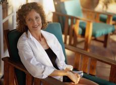 Photograph of a woman sitting on a porch chair