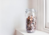 Glass jar with coins on window sill