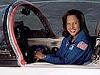 A female astronaut sits in the cockpit of a small jet