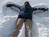 A girl lying in the snow making a snow angel