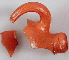 (photo) An orange-glazed mouth and handle of a water jug. (NPS)