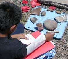 (photo) Kid works with Native American artifacts. (NPS)