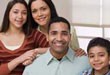 Photograph of a family sitting together and smiling