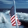 American flag at the back of a boat at sea.