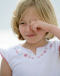 Photo: Young girl rubbing eye