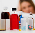 Woman looking at several bottles of medicine