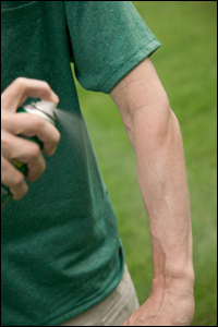 Man Spraying Repellent on arm