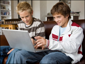 Two boys look at a laptop computer