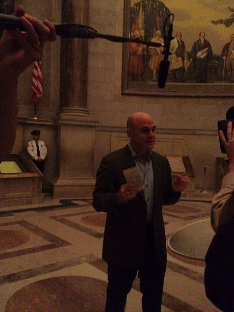 usnatarchives:

Hey, is that Peter Sagal of “Wait, Wait, Don’t Tell Me” in front of the Constitution? Why, yes! Just another day here at the National Archives for our press officers… (We hear he was very funny!)
Why is this image so dark? No flash photography is allowed in the Rotunda in order to preserve the fragile documents on display: Constitution, Bill of Rights, Declaration of Independence.
