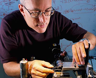 Mechanical engineer Jon Pratt makes an adjustment to the prototype NIST Electrostatic Force Balance designed to measure nanoscale forces. Image copyright Robert Rathe.