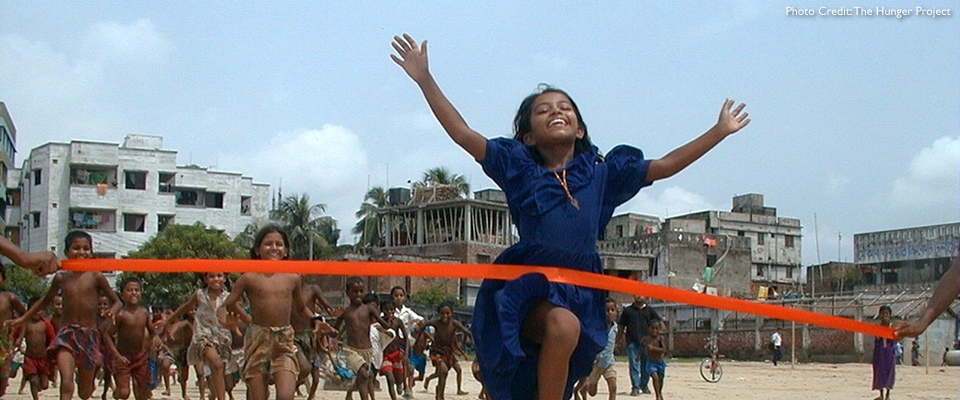 Young woman running across the finish line. Photo credit: The Hunger Project