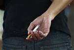 An Indonesian youth holds a cigarette while waiting for a train in Jakarta May 24, 2012. REUTERS/Beawiharta