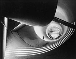 Photo: man in a wind tunnel, part of an aircraft in foreground.