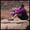 Photo: A man sitting on a rock.