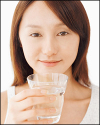 Una mujer con un vaso de agua